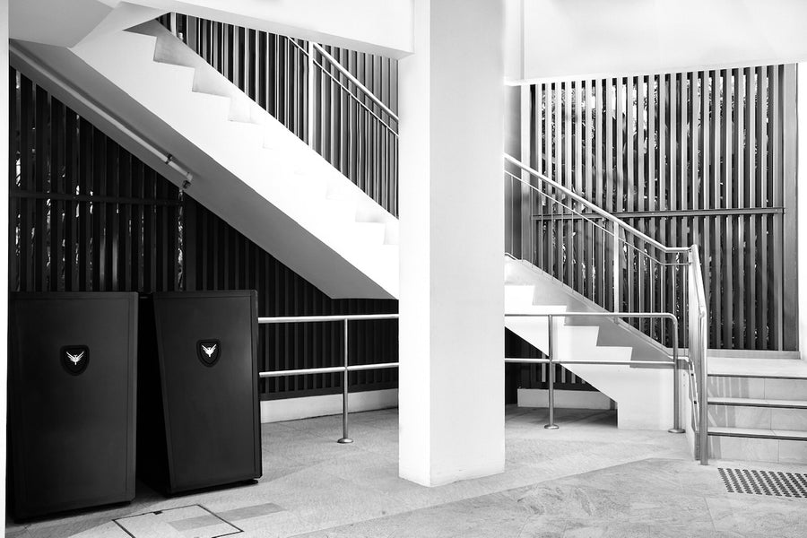 Modern interior with black horizontal Bicycle Storage Pods in a commercial setting and a staircase.